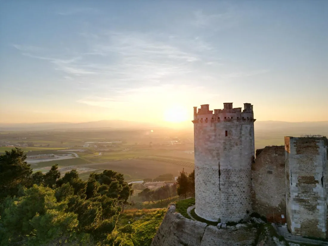 Una torre della Fortezza di Lucera al tramonto, con la campagna sotto