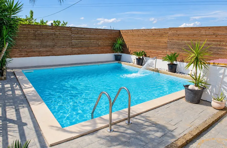 La piscina con la scaletta e le piante in vaso